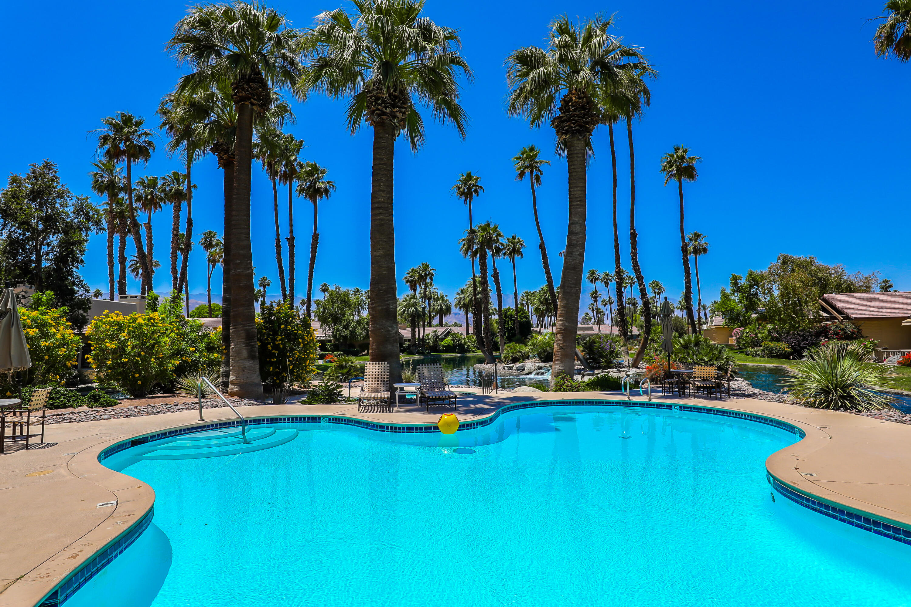 164 Deer Spring Way Palm Desert, CA 92211 - Photo 24 of 30 a view of a swimming pool with a table and chairs
