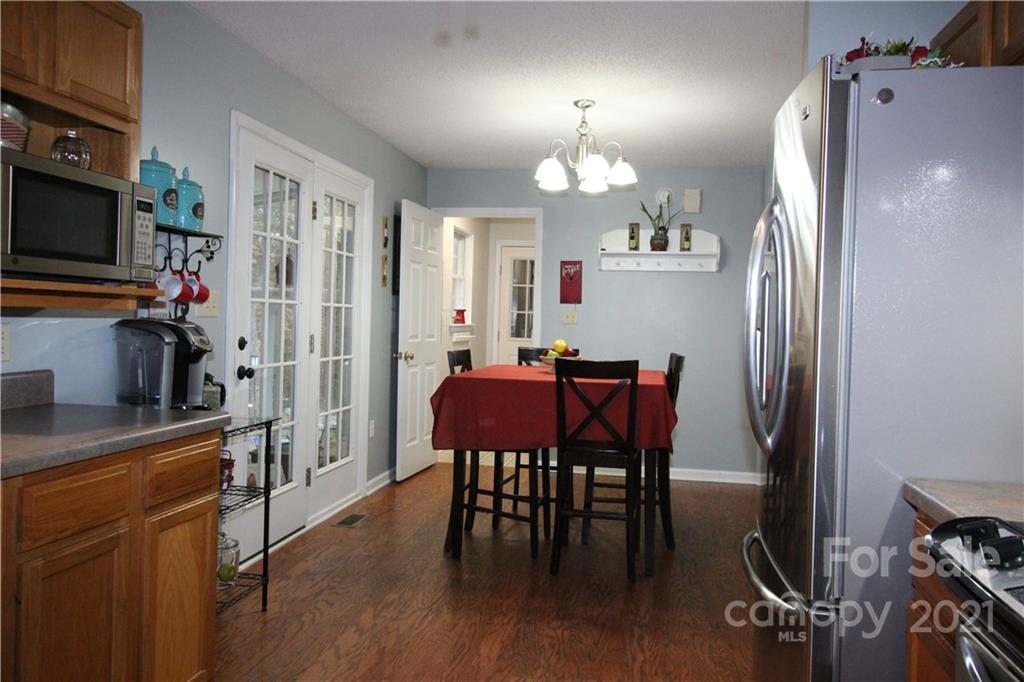 1900 Mt Pleasant Road North Concord, NC 28025 - Photo 11 of 21 a kitchen with stainless steel appliances a dining table chairs refrigerator and sink