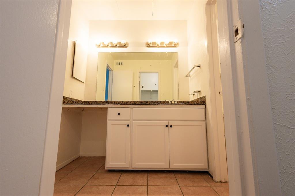 5540 Boca Raton Boulevard, Unit 175 Fort Worth, TX 76112 - Photo 26 of 30 Bathroom featuring a textured wall, vanity, and light tile patterned floors