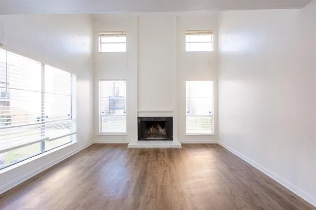 wooden floor fireplace and windows in an empty room