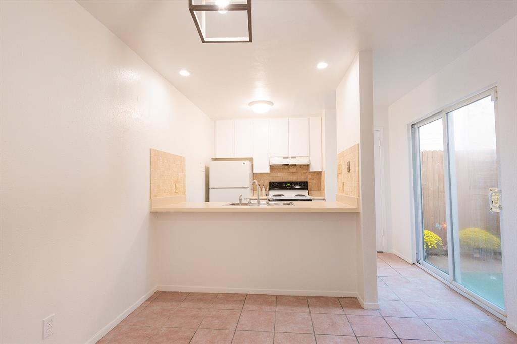 5540 Boca Raton Boulevard, Unit 175 Fort Worth, TX 76112 - Photo 7 of 30 Kitchen with light countertops, backsplash, light tile patterned floors, freestanding refrigerator, and recessed lighting
