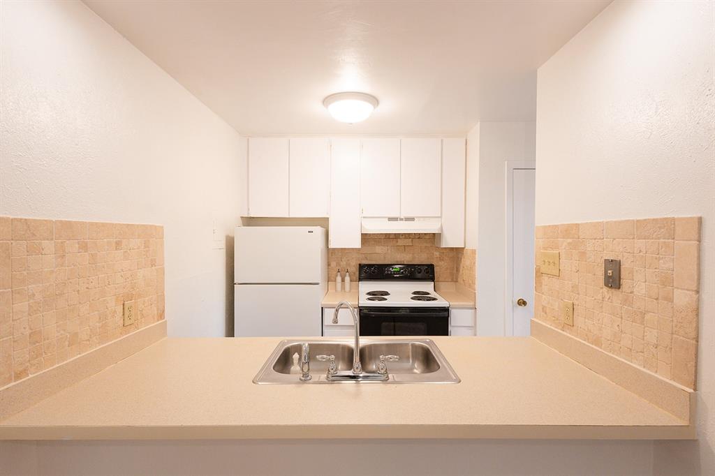 5540 Boca Raton Boulevard, Unit 175 Fort Worth, TX 76112 - Photo 8 of 30 Kitchen with backsplash, freestanding refrigerator, electric range oven, and light countertops