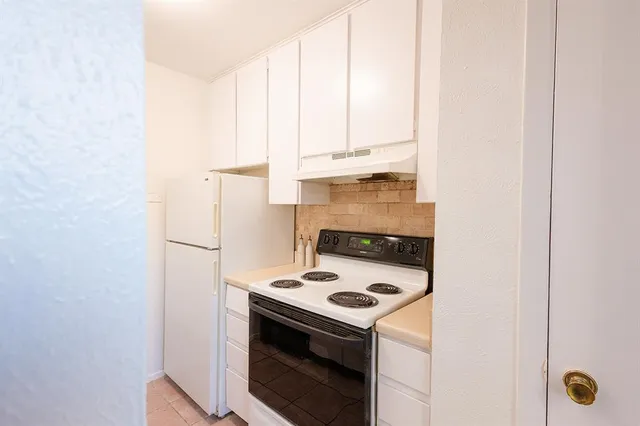 a kitchen with a stove and a white cabinet