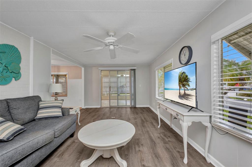 10100 Burnt Store Road, Unit 21 Punta Gorda, FL 33950 - Photo 18 of 61 a living room with furniture a flat screen tv and a large window