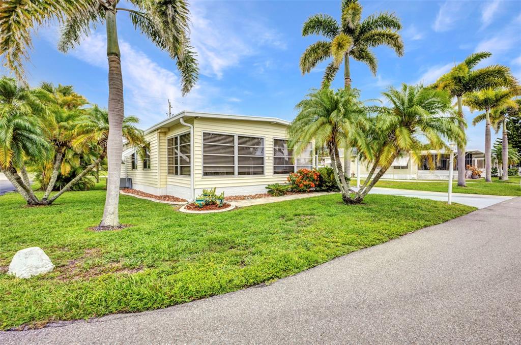 10100 Burnt Store Road, Unit 21 Punta Gorda, FL 33950 - Photo 2 of 61 a view of a house with a yard and palm trees