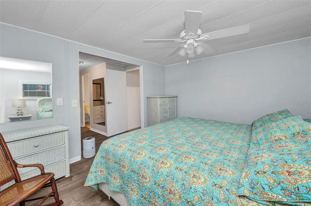 10100 Burnt Store Road, Unit 21 Punta Gorda, FL 33950 - Photo 24 of 61 a bedroom with a bed and a chandelier