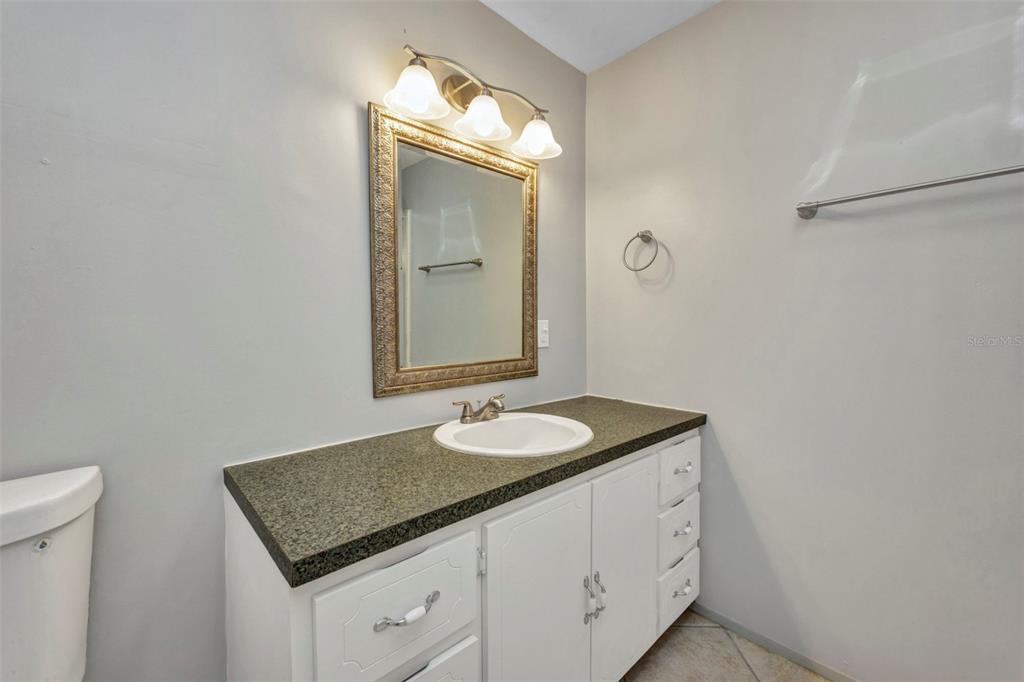 10100 Burnt Store Road, Unit 21 Punta Gorda, FL 33950 - Photo 27 of 61 a bathroom with a granite countertop sink and a mirror