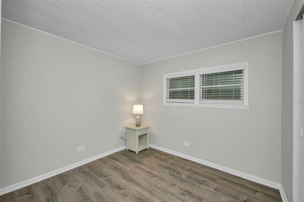10100 Burnt Store Road, Unit 21 Punta Gorda, FL 33950 - Photo 30 of 61 a view of an empty room with a window and wooden floor