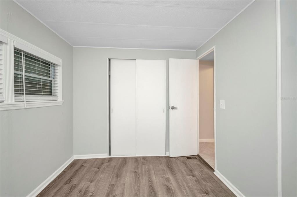 10100 Burnt Store Road, Unit 21 Punta Gorda, FL 33950 - Photo 31 of 61 a view of an empty room with wooden floor and a window
