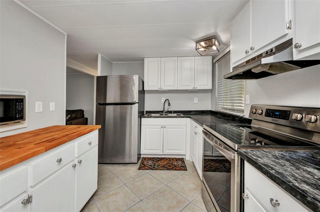 10100 Burnt Store Road, Unit 21 Punta Gorda, FL 33950 - Photo 8 of 61 a kitchen with a refrigerator and a stove top oven