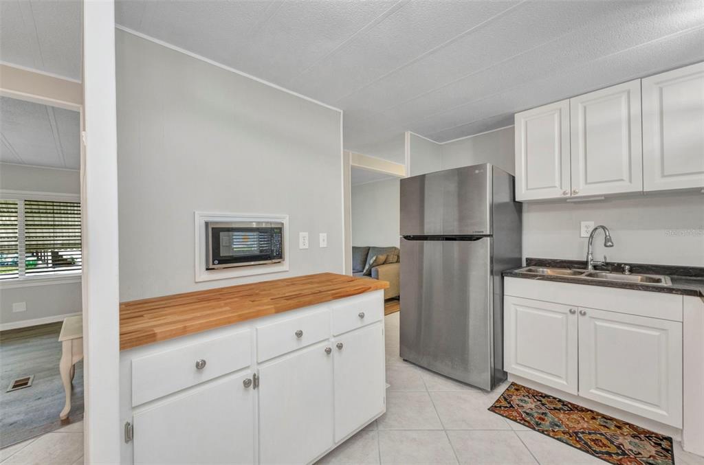 10100 Burnt Store Road, Unit 21 Punta Gorda, FL 33950 - Photo 10 of 61 a kitchen with a refrigerator sink and cabinets