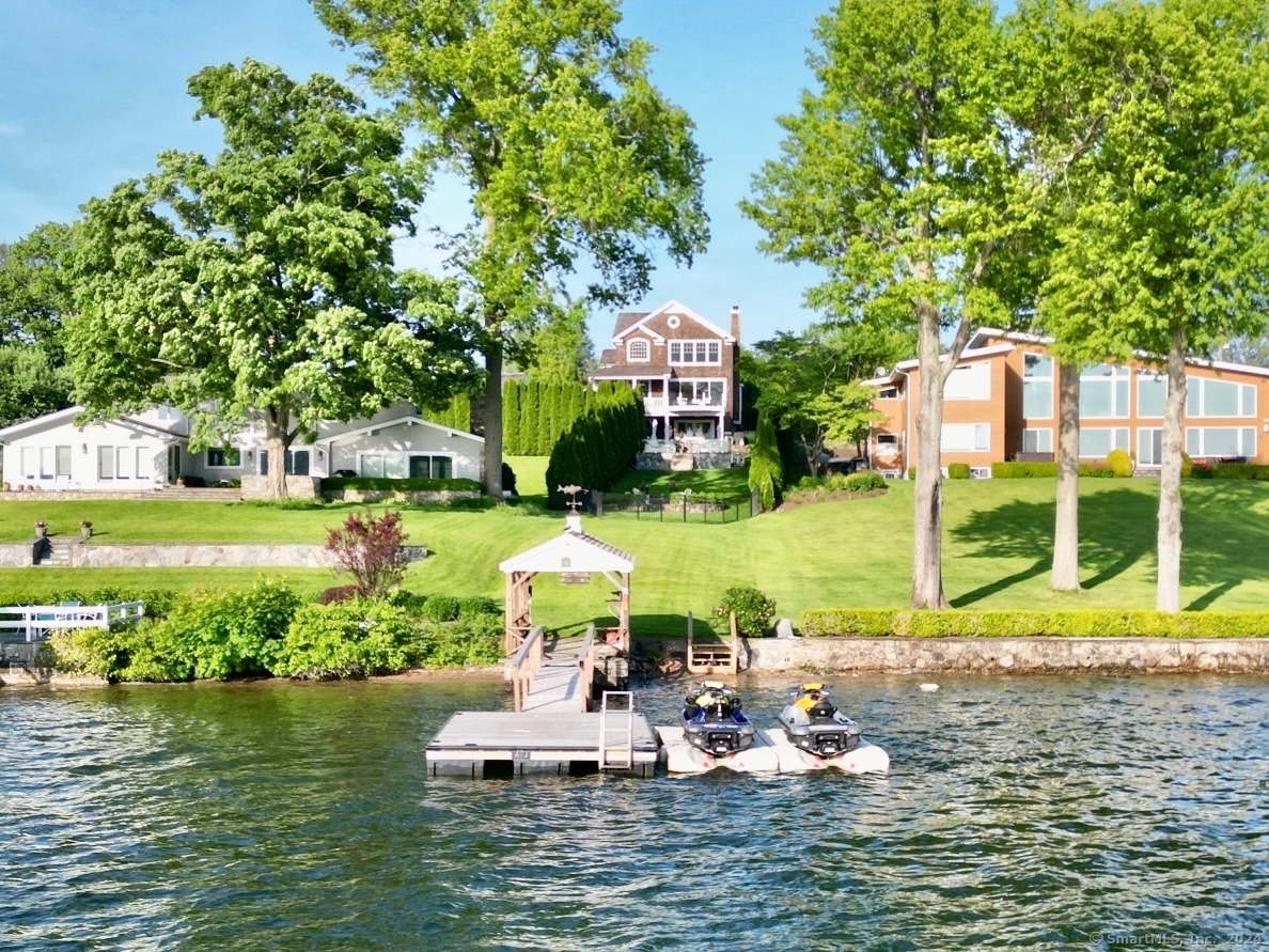 a view of a lake with lawn chairs under an umbrella