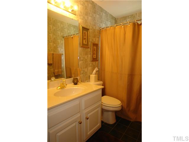 7012 Edgeview Court Raleigh, NC 27613 - Photo 19 of 25 a bathroom with a granite countertop sink toilet and shower