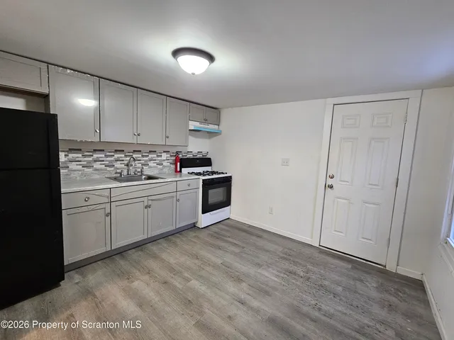 a kitchen with white cabinets and white appliances