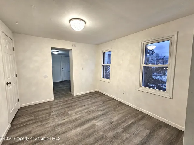 an empty room with windows and closet