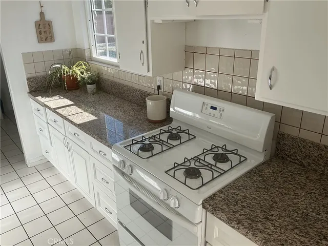 a stove top oven sitting inside of a kitchen