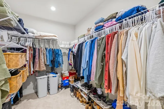 a view of walk in closet with clothes and shoes