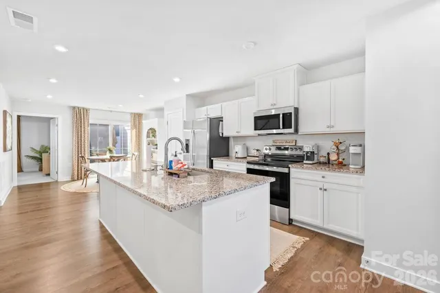 a kitchen with granite countertop a stove sink and cabinets