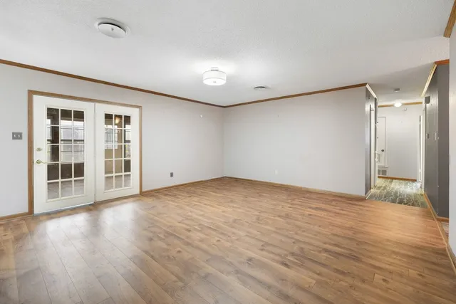 a view of empty room with wooden floor and windows
