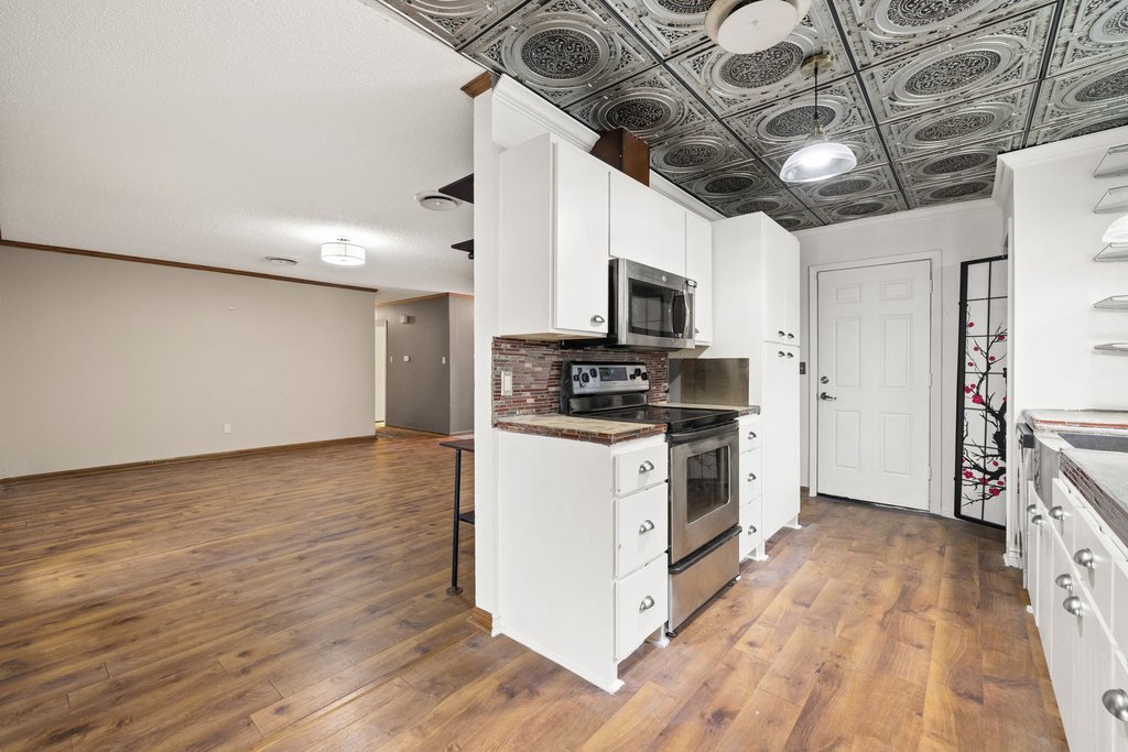 2204 Smith Avenue Taylor, TX 76574 - Photo 15 of 40 a kitchen with stainless steel appliances granite countertop a stove a sink and a microwave