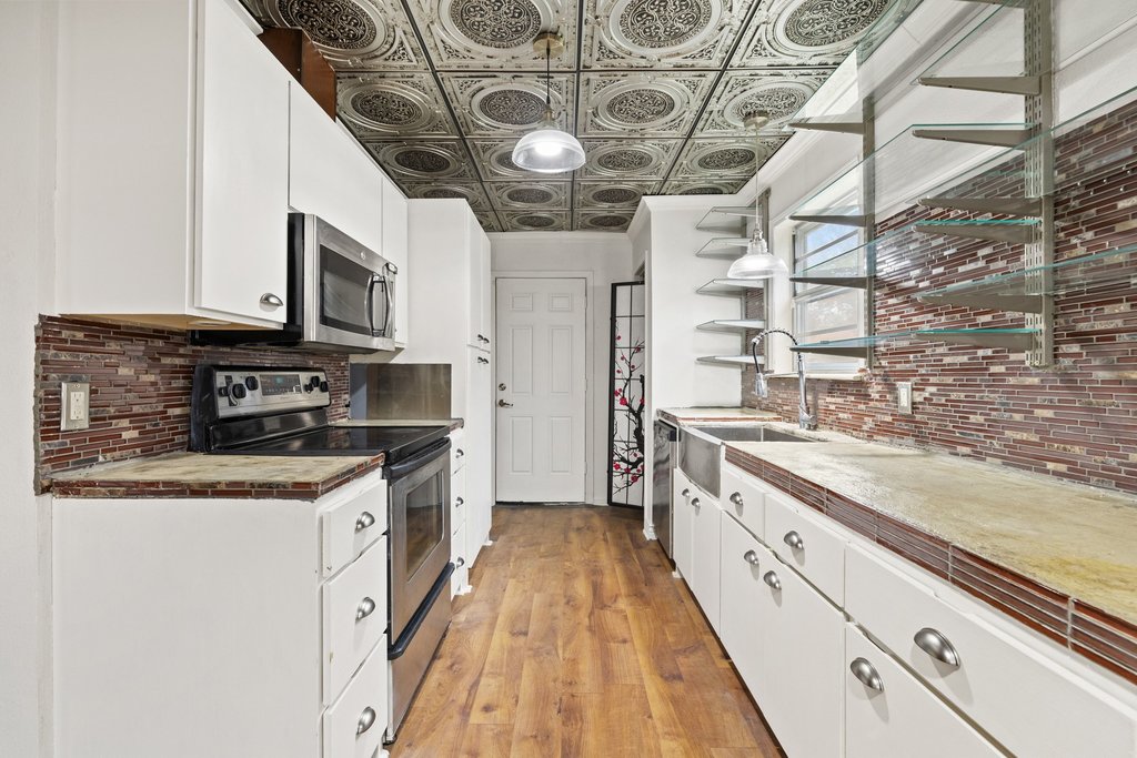 2204 Smith Avenue Taylor, TX 76574 - Photo 16 of 40 a large kitchen with stainless steel appliances granite countertop a stove a sink and dishwasher
