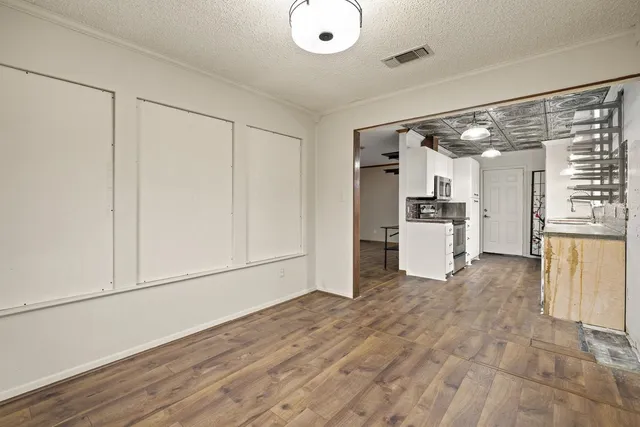 a kitchen with granite countertop a refrigerator and a stove top oven