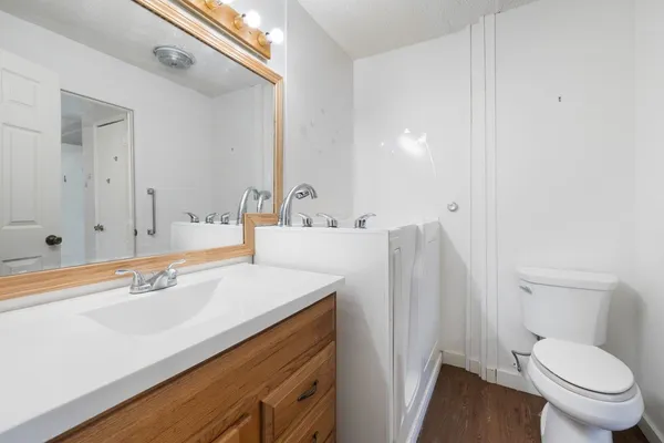 a bathroom with a sink a toilet and a large mirror
