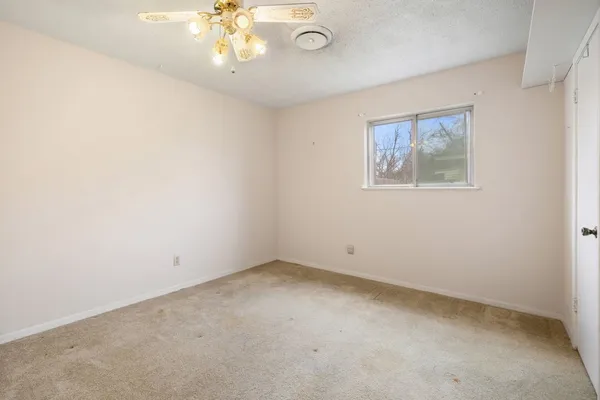 an empty room with a chandelier fan