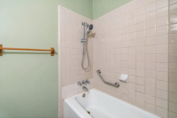 a bathroom with a white bath tub and shower