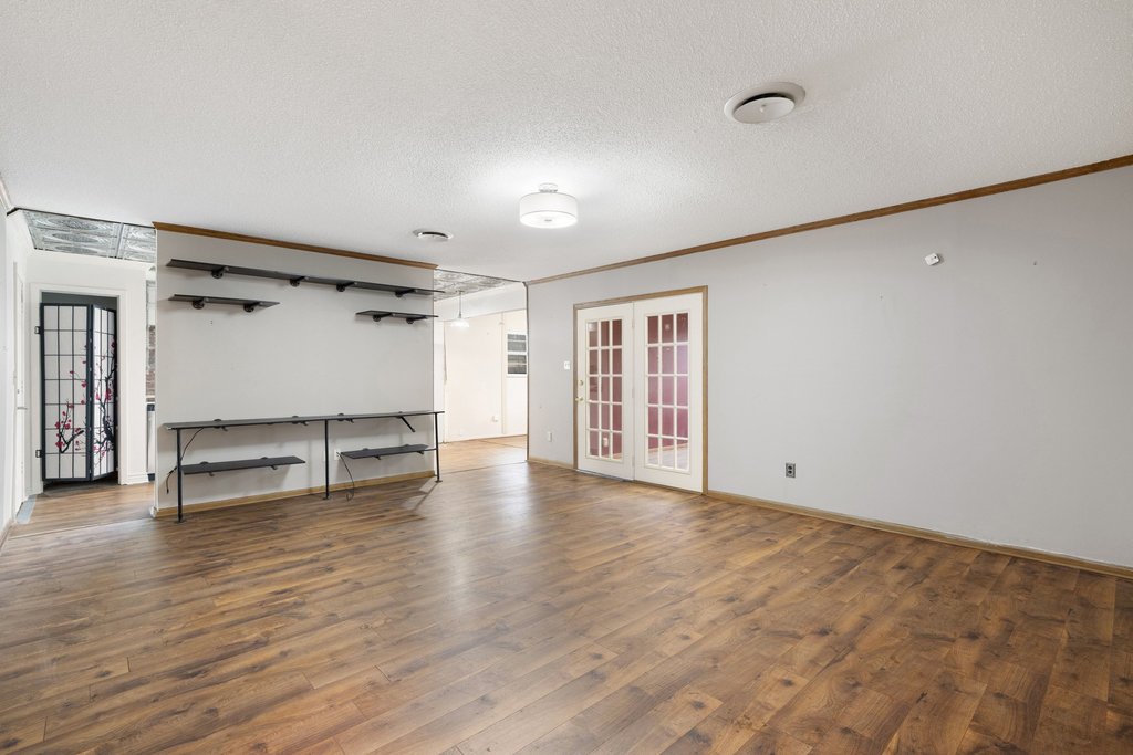 2204 Smith Avenue Taylor, TX 76574 - Photo 7 of 40 a view of an empty room with wooden floor and a window