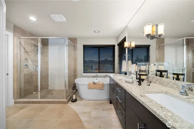 a bathroom with a tub a sink double vanity and a mirror