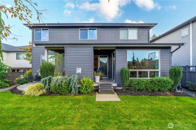 a view of house with a yard and potted plants