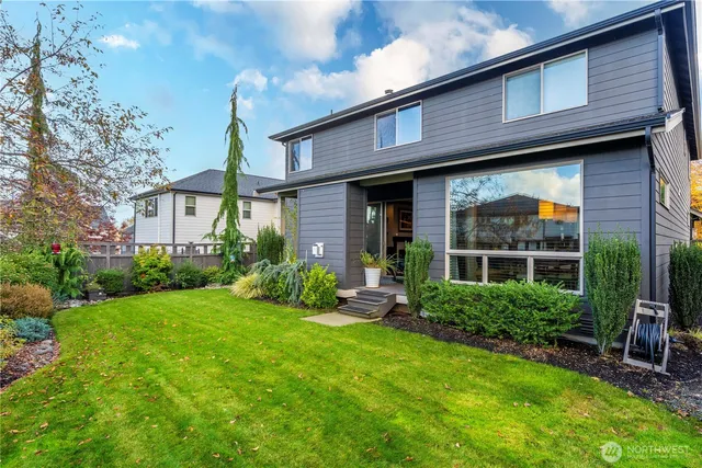 a view of a house with brick walls and a yard with plants