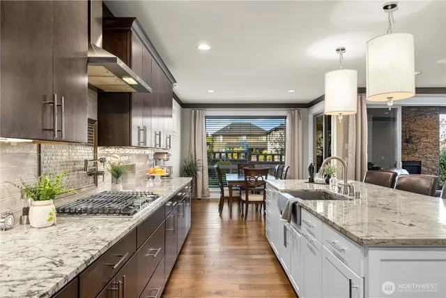 a kitchen with granite countertop a sink cabinets and stainless steel appliances
