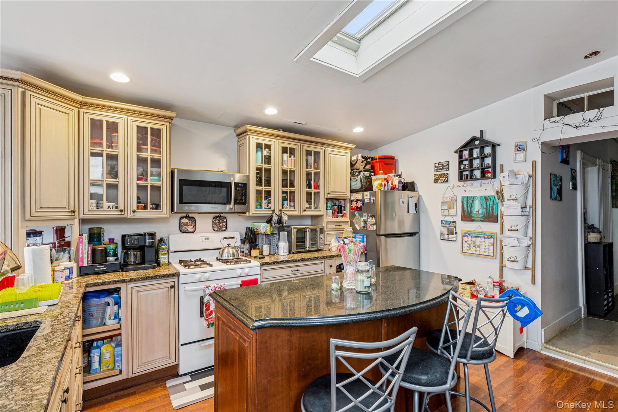 250 Main Road Riverhead, NY 11901 - Photo 4 of 31 a kitchen with stainless steel appliances granite countertop a dining table and chairs with wooden floor