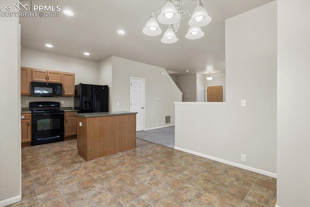 2740 Stonecrop Ridge Grove Colorado Springs, CO 80910 - Photo 14 of 42 Kitchen with black appliances, decorative light fixtures, a chandelier, recessed lighting, and dark countertops