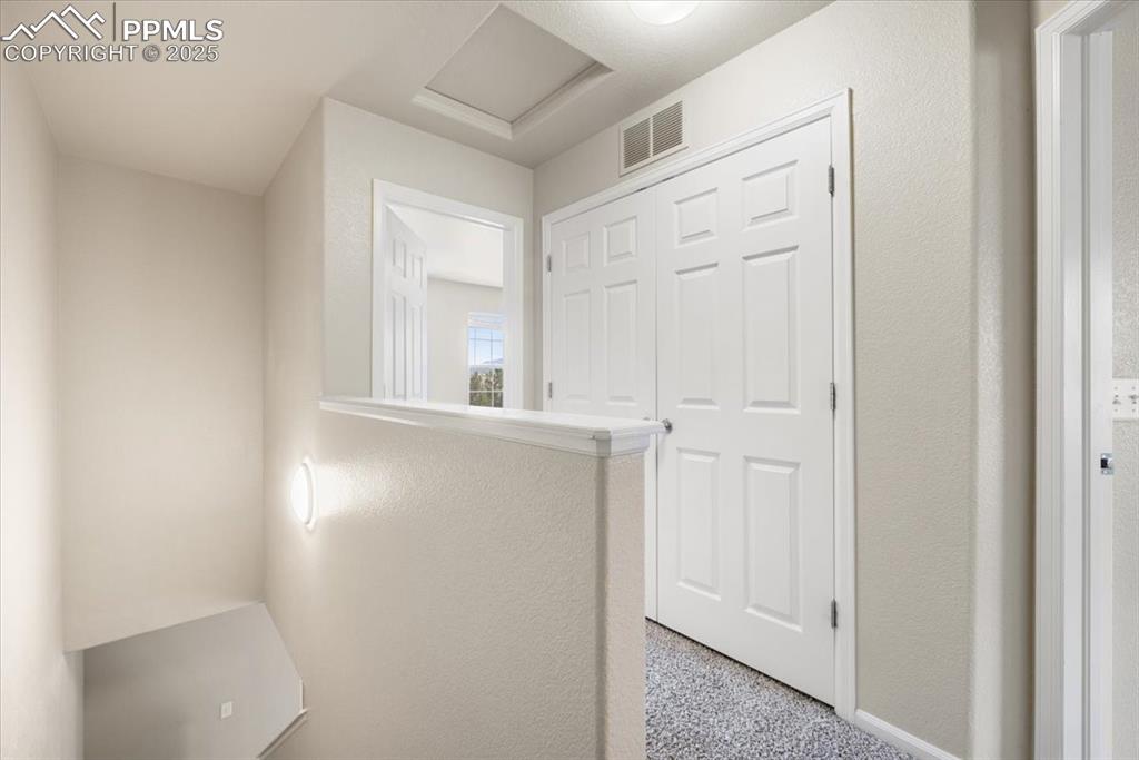 2740 Stonecrop Ridge Grove Colorado Springs, CO 80910 - Photo 20 of 42 Hall featuring a textured wall and attic access