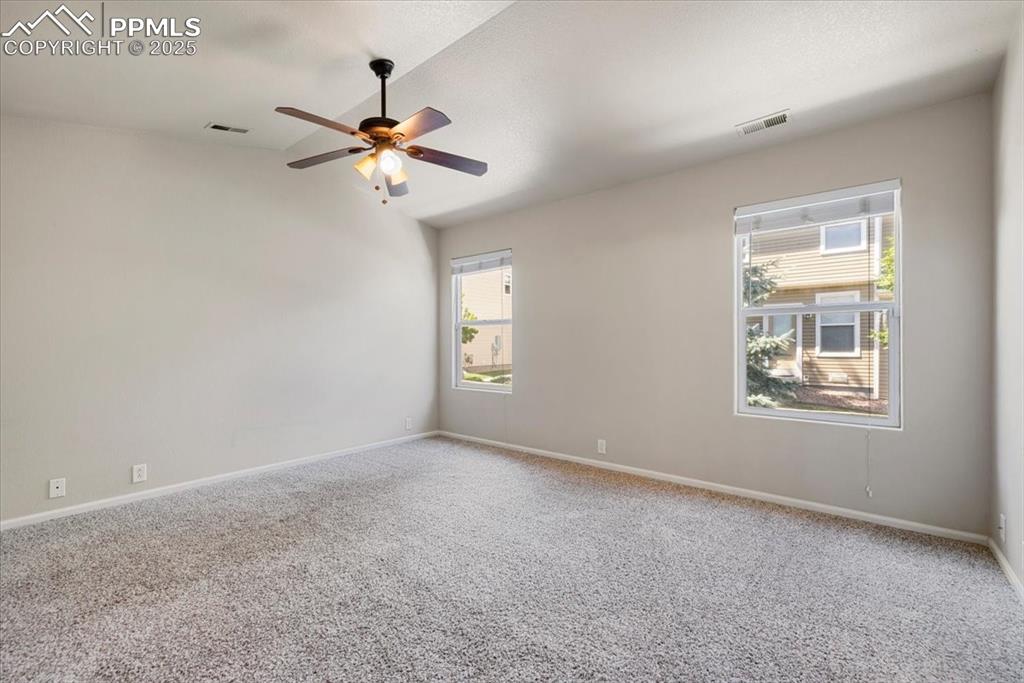 2740 Stonecrop Ridge Grove Colorado Springs, CO 80910 - Photo 27 of 42 Carpeted spare room with vaulted ceiling and ceiling fan
