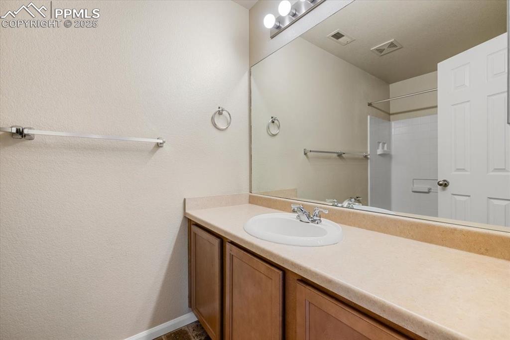 2740 Stonecrop Ridge Grove Colorado Springs, CO 80910 - Photo 31 of 42 Full bathroom with vanity and a textured wall