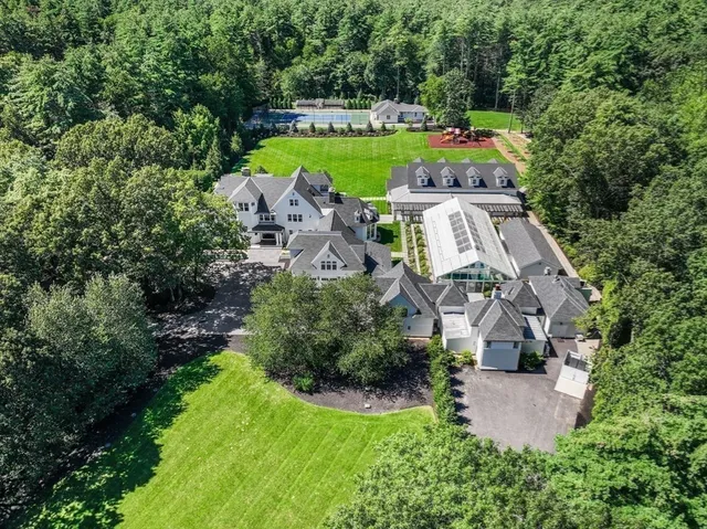 an aerial view of a house with a garden and lake view