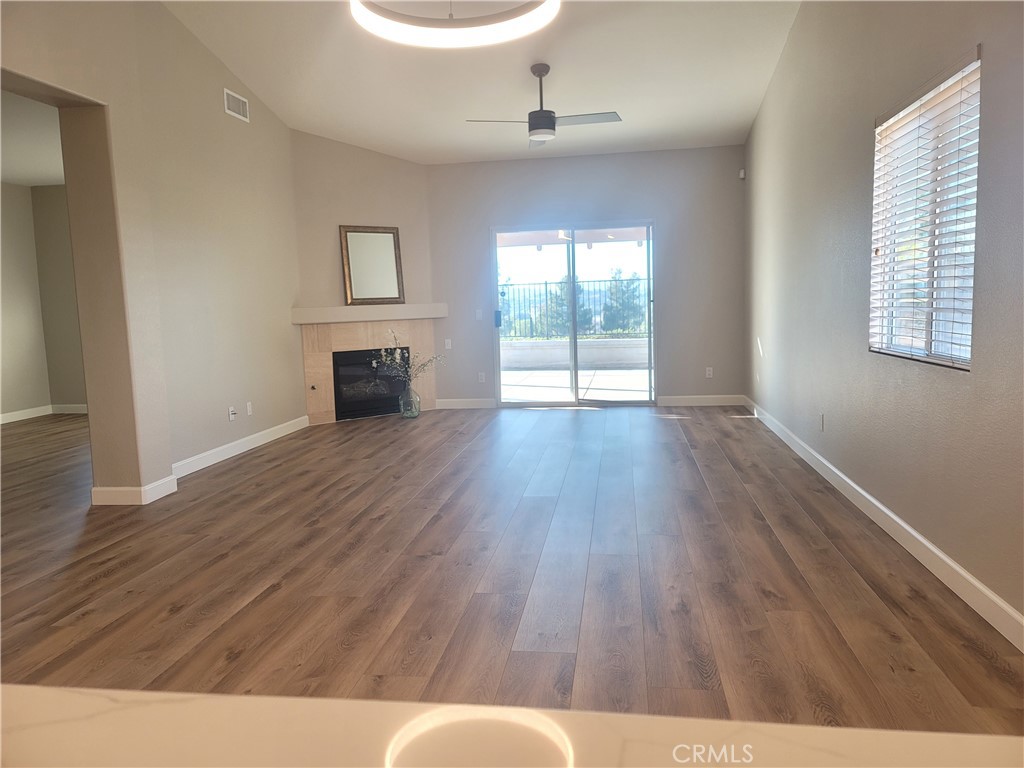 44915 Machon Road Temecula, CA 92592 - Photo 33 of 40 an empty room with wooden floor fireplace and windows