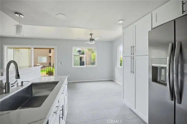 a kitchen with a refrigerator sink and white cabinets