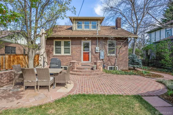 a backyard of a house with barbeque oven table and chairs