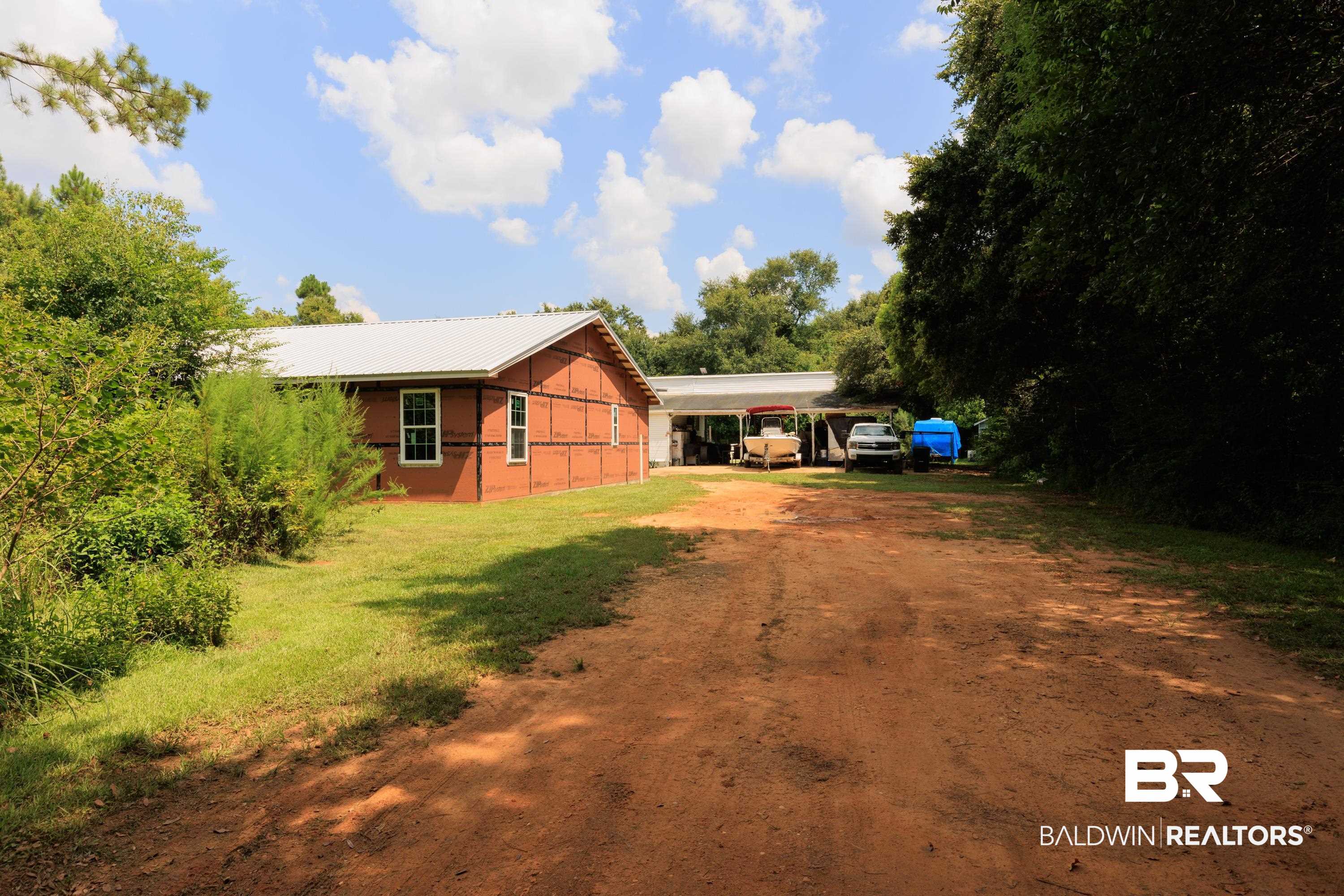 17385 County Road 16 Foley, AL 36535 - Photo 16 of 53 Exterior space featuring an attached carport, metal roof, a yard, and dirt driveway