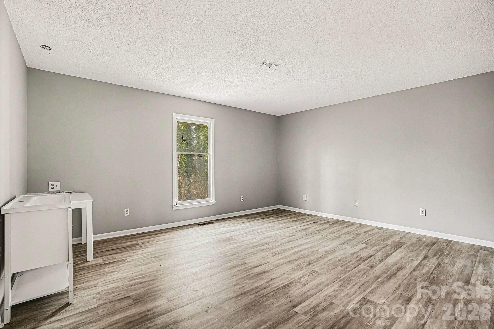 5509 Morgan Mill Road Monroe, NC 28110 - Photo 14 of 33 a view of an empty room with wooden floor and a window