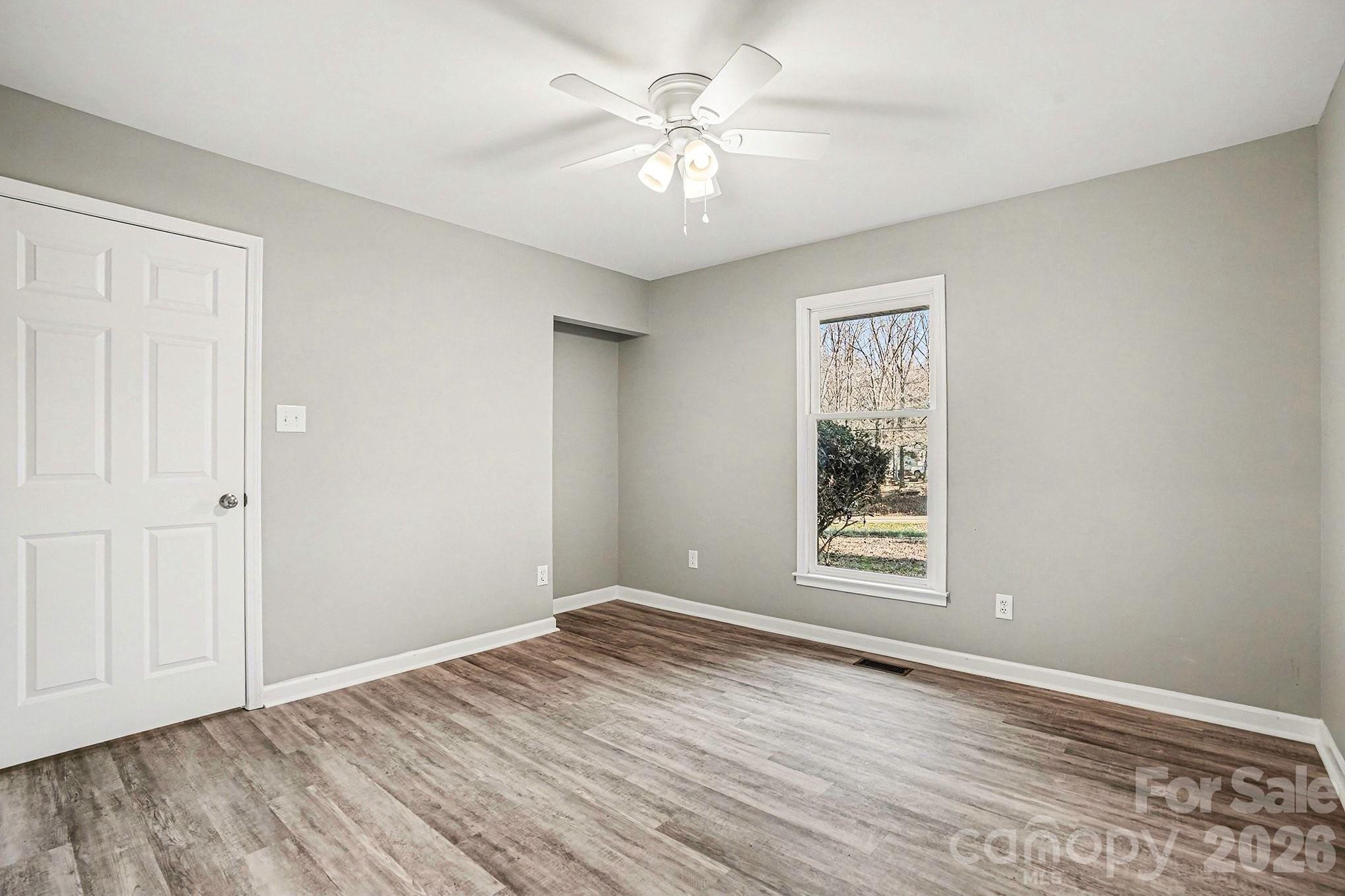 5509 Morgan Mill Road Monroe, NC 28110 - Photo 19 of 33 a view of an empty room with window and wooden floor