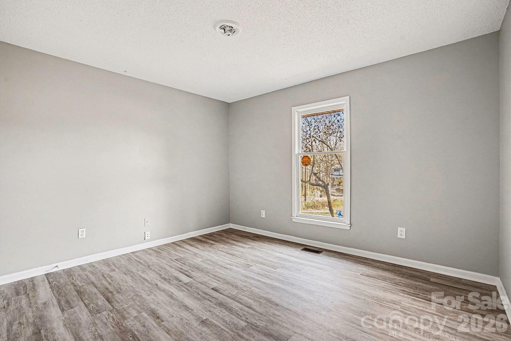 5509 Morgan Mill Road Monroe, NC 28110 - Photo 21 of 33 wooden floor in an empty room with a window