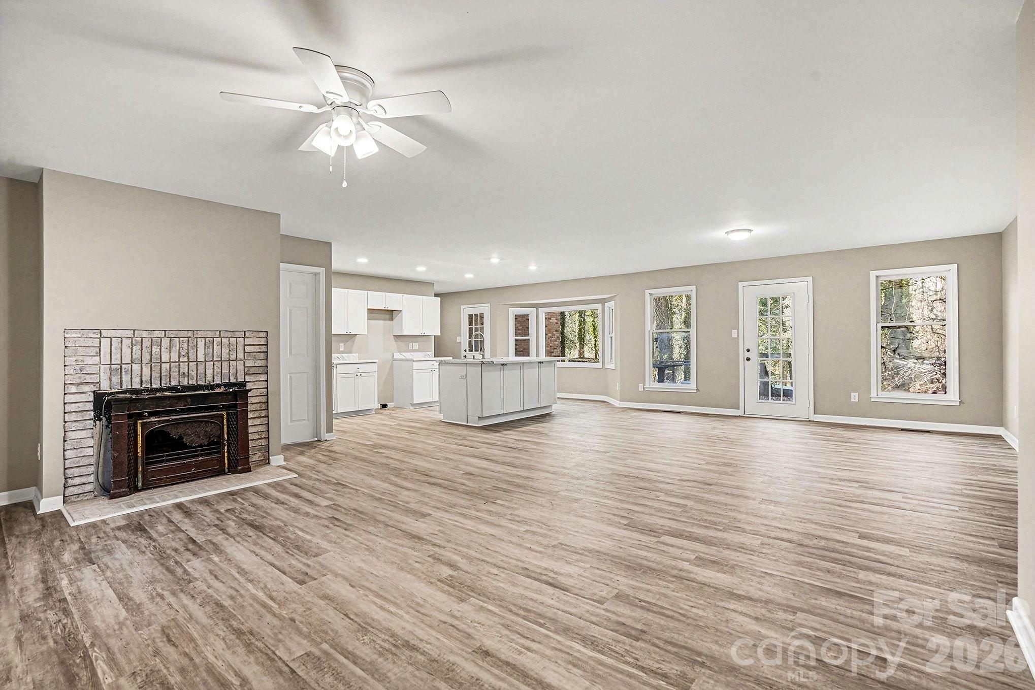 5509 Morgan Mill Road Monroe, NC 28110 - Photo 3 of 33 a view of an empty room with wooden floor fireplace and a window