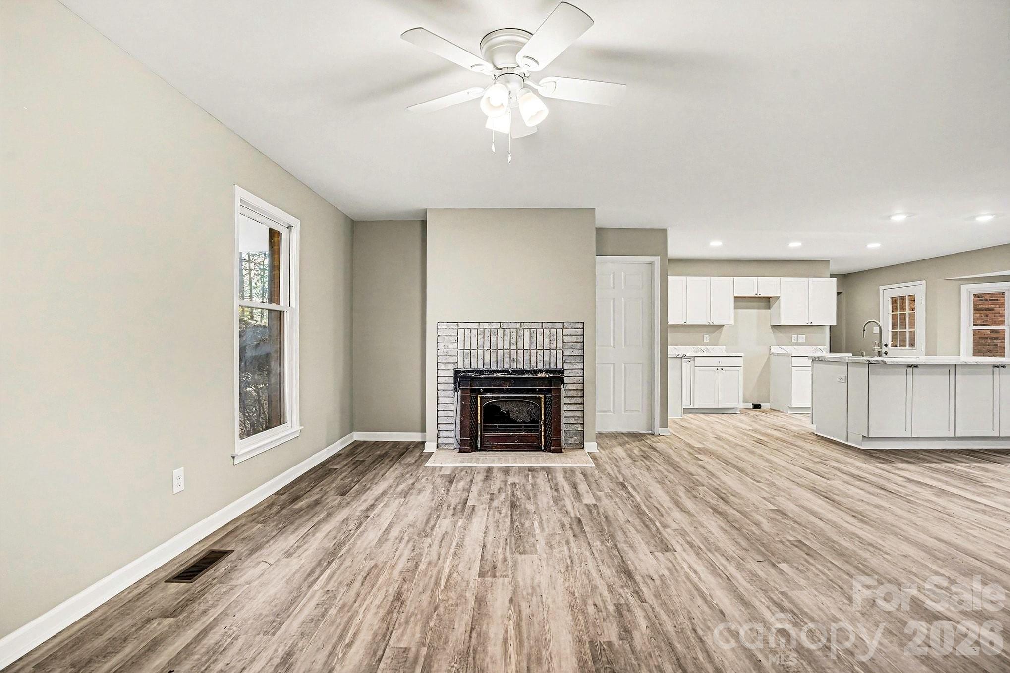 5509 Morgan Mill Road Monroe, NC 28110 - Photo 5 of 33 a view of a livingroom with a fireplace a ceiling fan and windows