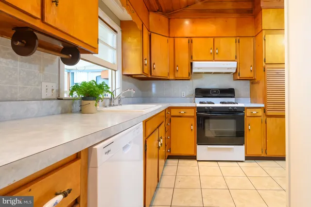 a kitchen with a sink a stove and cabinets